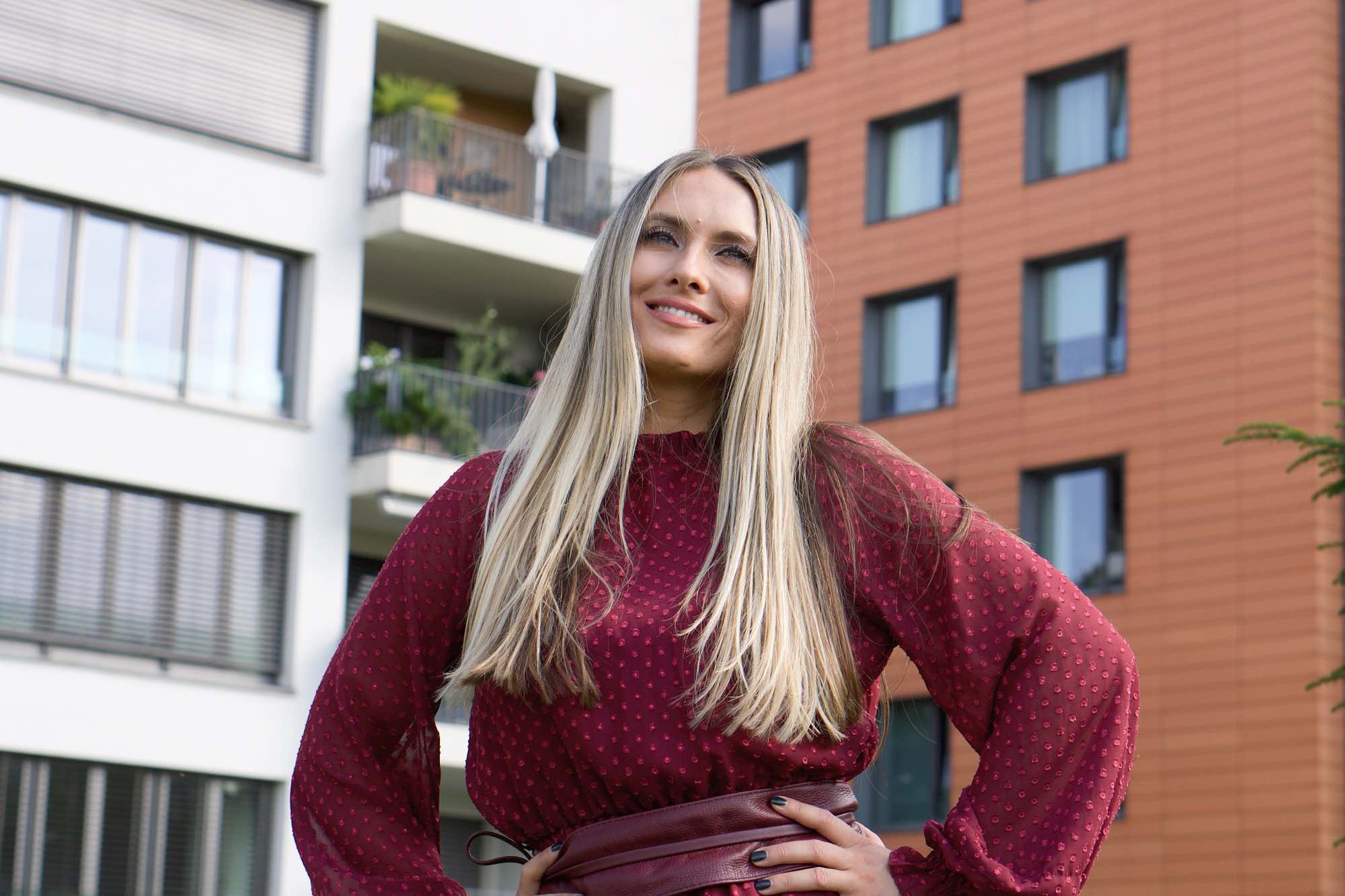 Iva Buric Zalac - Iva Zalac in einem roten Kleid vor einer Häuserfront