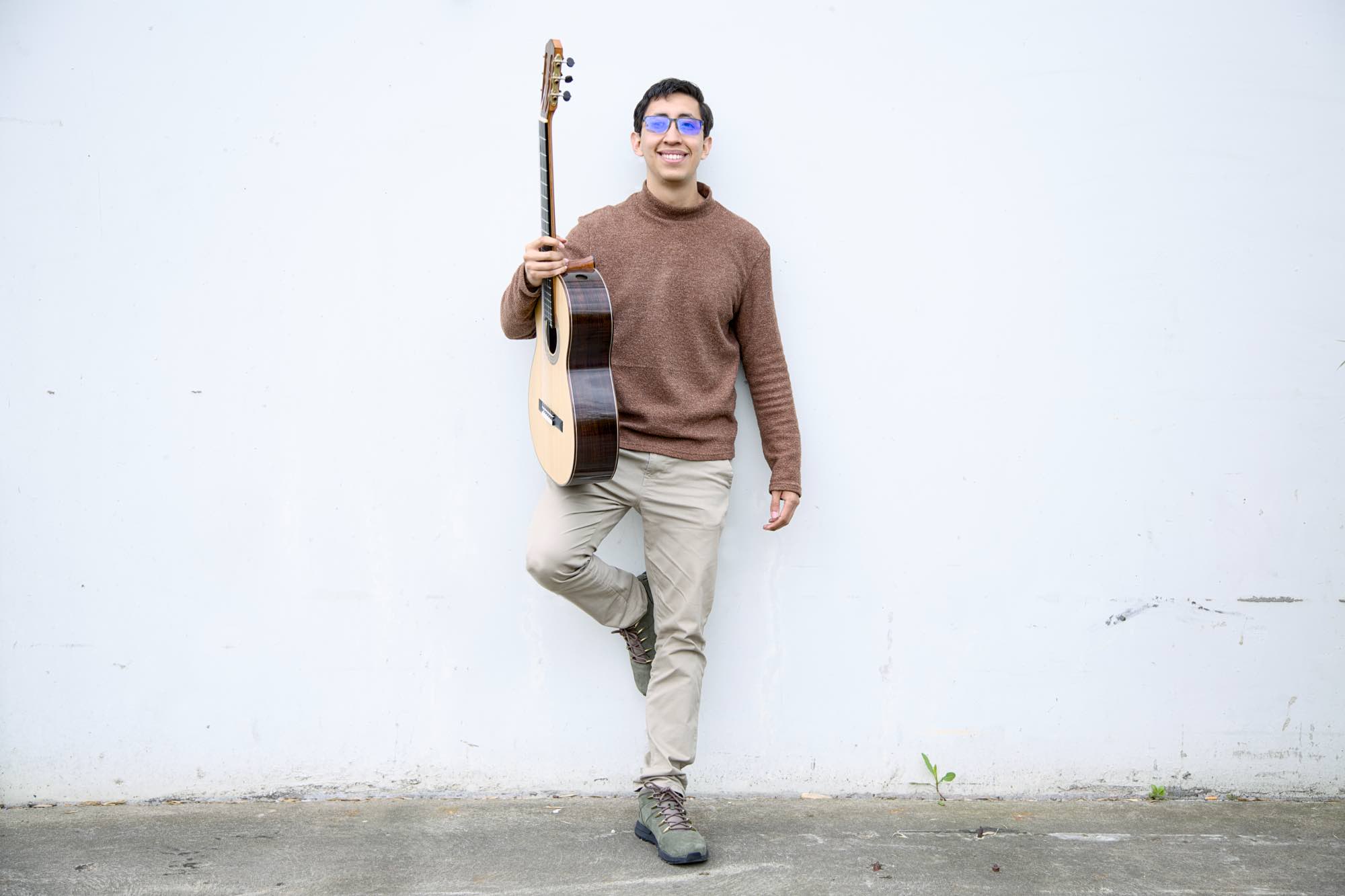 Jhostin Guzmán steht mit seiner Gitarre in der Hand vor einer Halle auf dem Gelände der Rheinhöfe