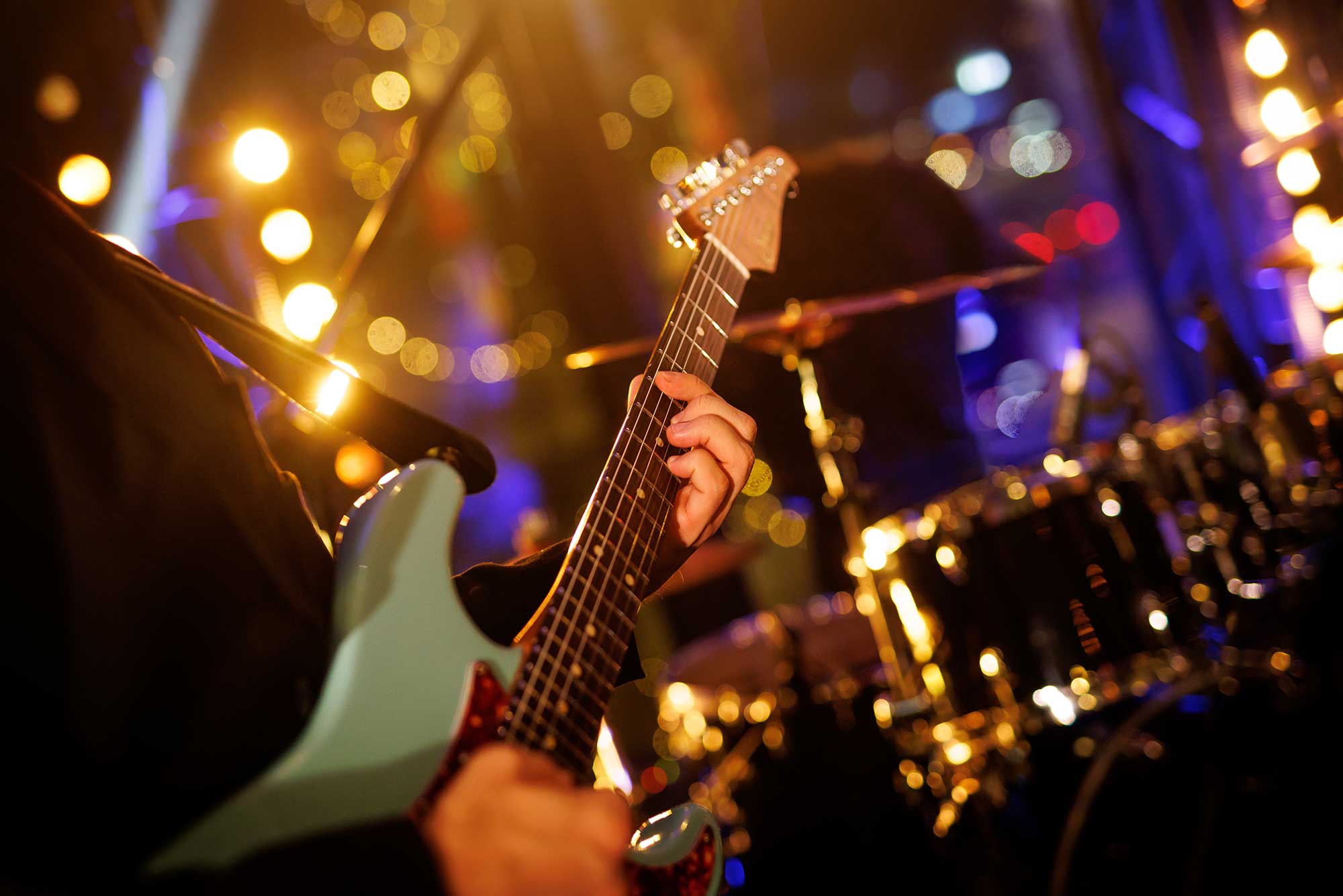 Gitarrist spielt auf der e-Gitarre auf der Buehne waehrend eines live-Konzerts