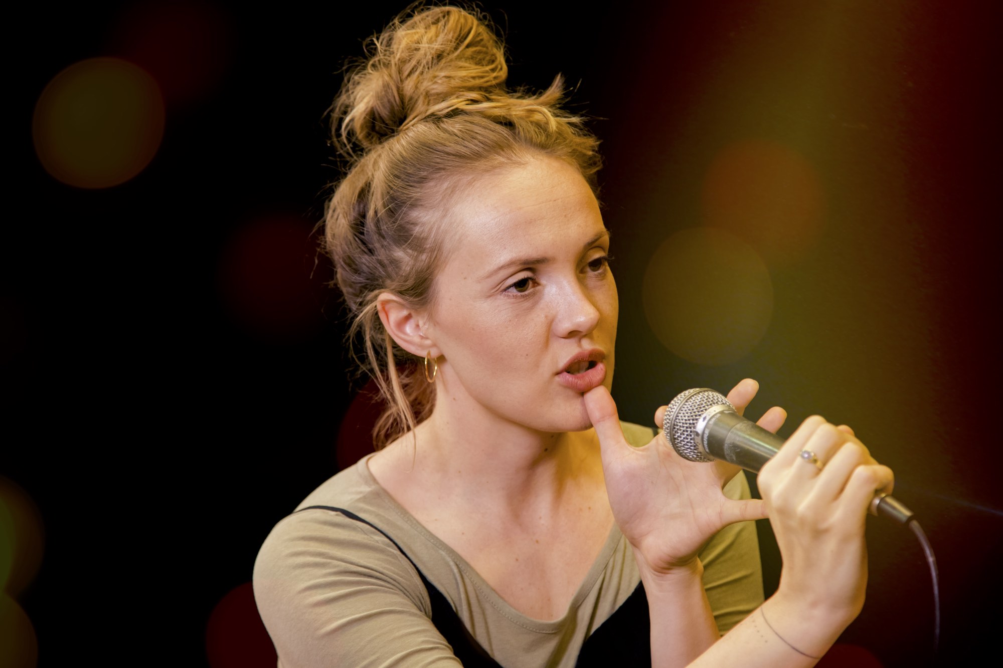 Die Gesangslehrerin Melissa Muther haelt ein Mikrofon in der Hand waehrend des Workshops